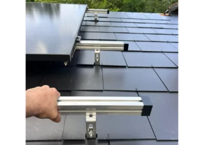 Découpe précise des ardoises autour des supports de rails pour l'installation de panneaux solaires sur la toiture à Mons, garantissant une installation sûre et esthétique.