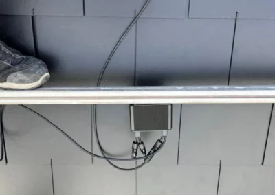 Installation de l'onduleur pour panneaux solaires sur la toiture, essentiel pour convertir l'énergie solaire en électricité utilisable.