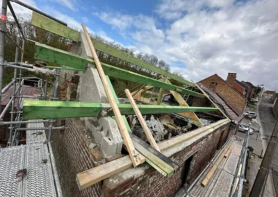 Rénovation de toiture à Roux montrant la préparation de la structure avec des pannes de bois vertes, en attente de la pose des chevrons.