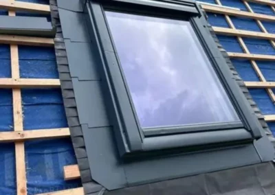 installation de la fenêtre de toit Velux avec une collerette d'étanchéité sur la toiture. La collerette assure une étanchéité maximale contre les infiltrations d'eau tout en préservant l'isolation de la toiture rénovée.