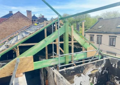 Rénovation de toiture à Roux avec l'installation d'une ferme de charpente en bois pour soutenir les pannes de la toiture. La structure est en cours de construction avec une sous-toiture en place pour protéger temporairement la maison.