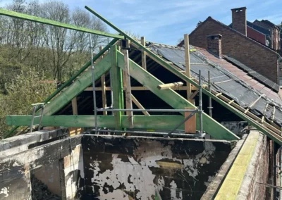 Rénovation de toiture à Roux pour la ferme de charpente en bois renforcée et les pannes installées pour soutenir la future couverture de toit. Une sous-toiture est en cours de pose pour préparer la mise en place des tuiles.